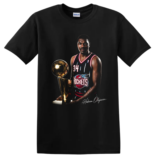 Hakeem Olajuwon in Houston Rockets No. 34 uniform beside championship trophy on a Black T Shirt