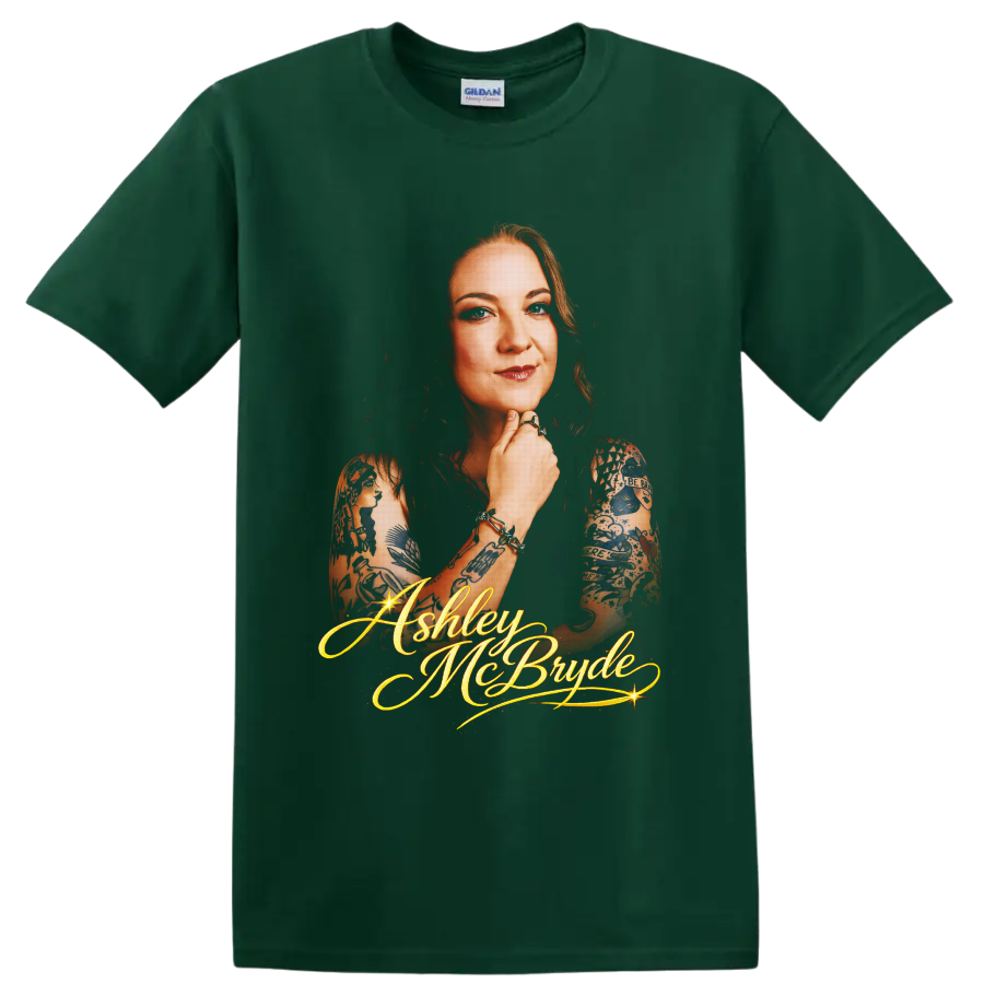 Ashley McBryde portrait with tattoo art and glowing gold script lettering on a Forest Green T Shirt