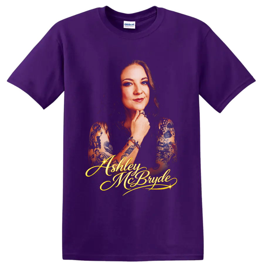 Ashley McBryde portrait with tattoo art and glowing gold script lettering on a Purple T Shirt